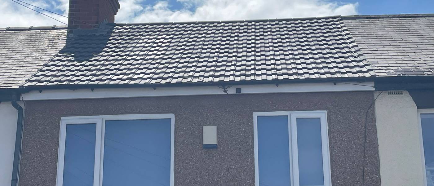 Pitched roof re-covered with interlocking tiles and new guttering